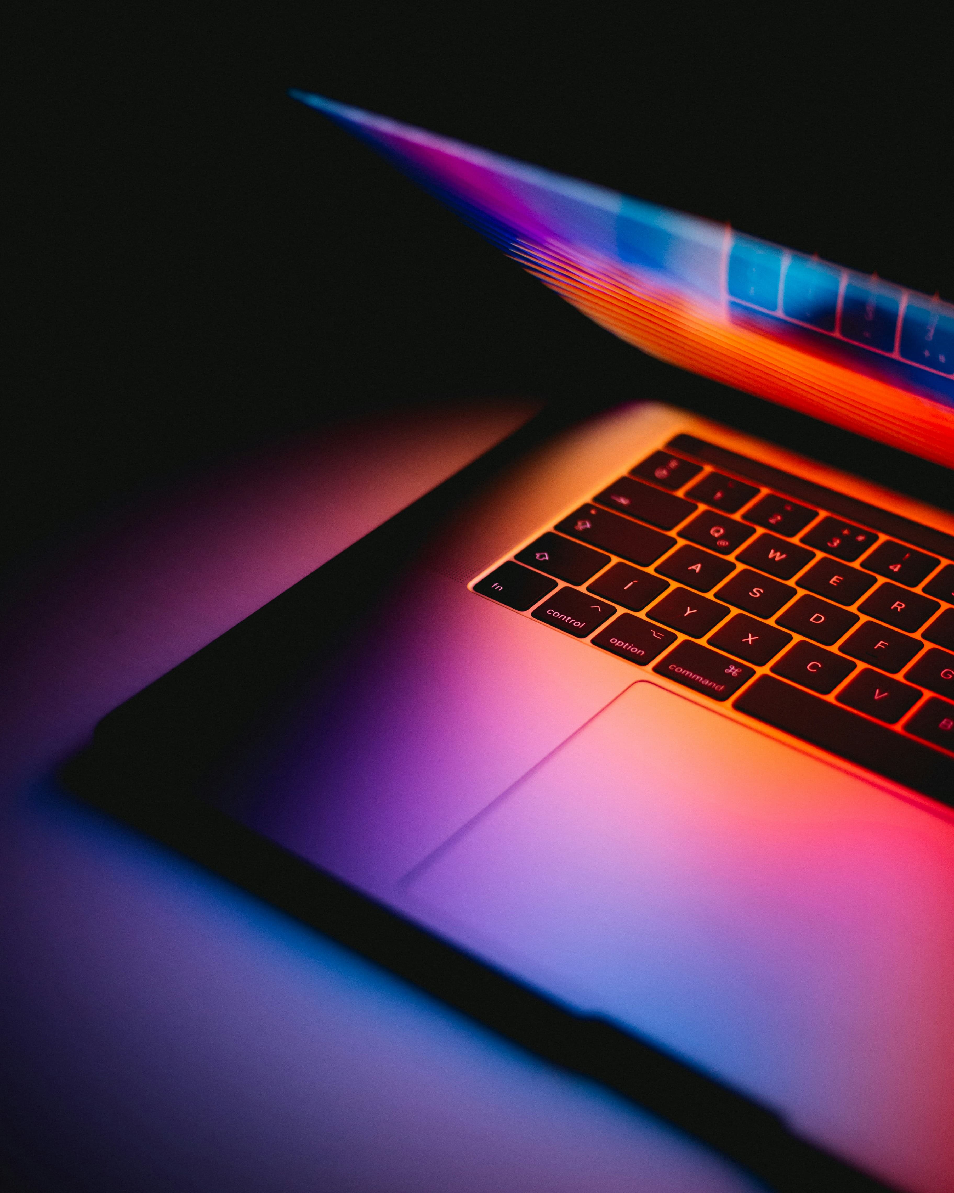 A glowing laptop in a dark room